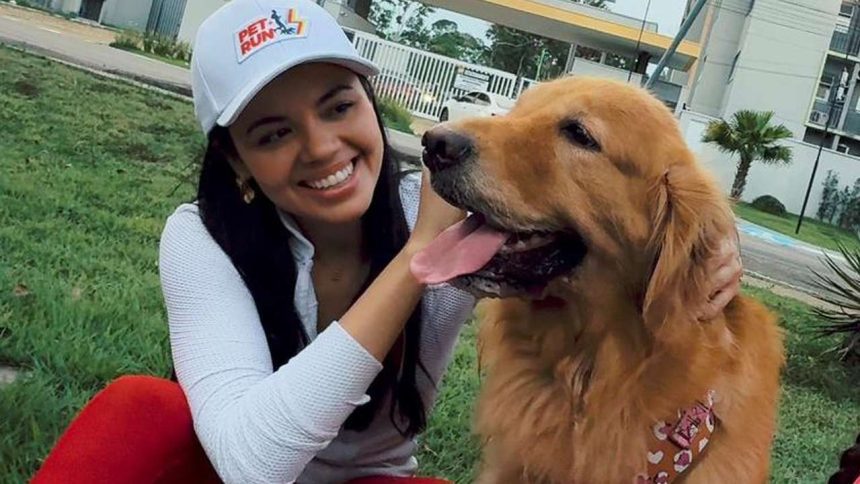 Mulher sorrindo com cachorro golden retriever em evento Pet Run