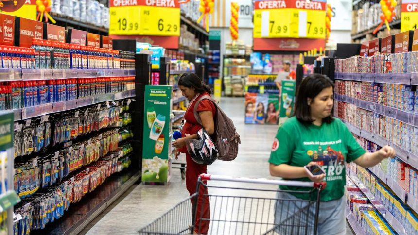 Mulheres comprando em supermercado, com promoções de produtos. Uma delas está grávida e a outra com carrinho de compras.