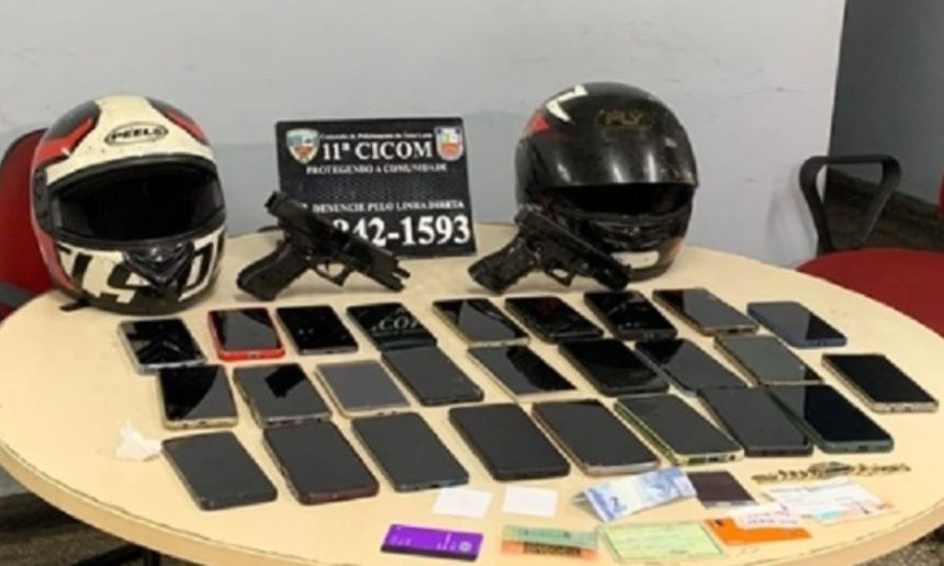 Objetos apreendidos em operação policial: capacetes, armas, celulares e documentos.