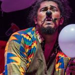 Palhaço com nariz vermelho e balão branco em festival de teatro