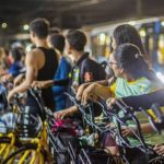 Pessoas alugam bicicletas amarelas em evento Pedala Livre na Ponta Negra, Manaus.