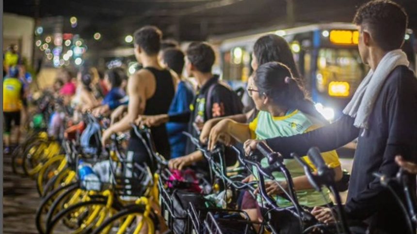 Pessoas alugam bicicletas amarelas em evento Pedala Livre na Ponta Negra, Manaus.