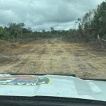 Pista de avião clandestina em área de mata, veículo da polícia no local.