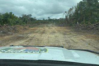 Pista de avião clandestina em área de mata, veículo da polícia no local.
