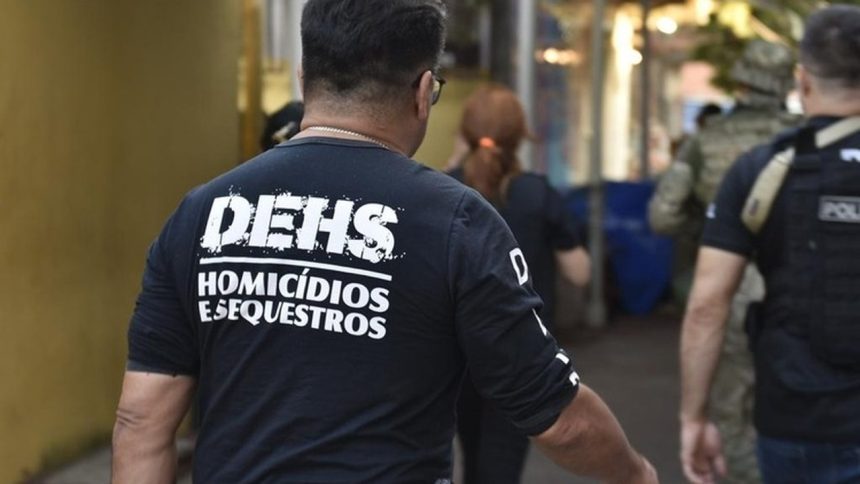 Policial com a inscrição DEHS (Divisão de Homicídios e Sequestros) em ação.