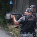 Policial da ROCAM com arma em ação durante operação.