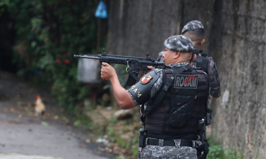 Policial da ROCAM com arma em ação durante operação.