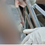 Policial manuseando instrumentos em cena de crime em Manaus.