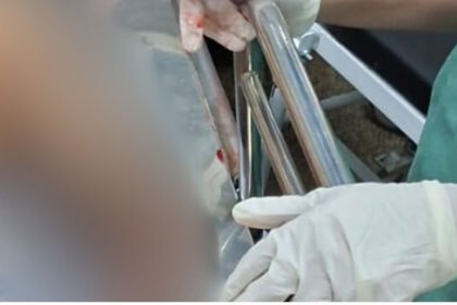 Policial manuseando instrumentos em cena de crime em Manaus.