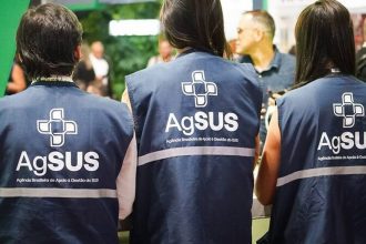 Profissionais de saúde com coletes AgSUS em evento sobre saúde.