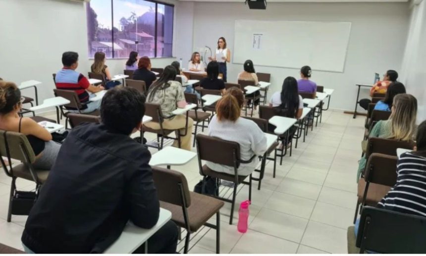 Sala de aula com estudantes e palestrante, possível apresentação sobre concurso.
