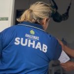 Servidora da SUHAB orienta morador durante recadastramento no Conjunto Cidadão XII