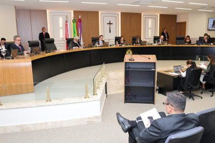 Sessão de julgamento com juízes e advogados em plenário.