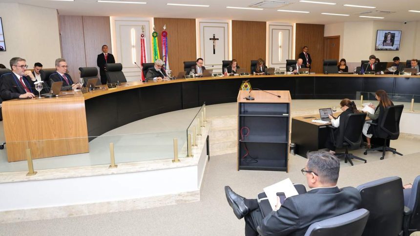 Sessão de julgamento com juízes e advogados em plenário.