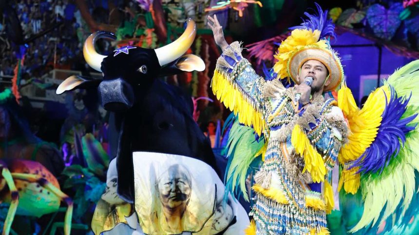 Show do Boi Caprichoso no Bumbódromo, com cantor e boi-bumbá estilizado.
