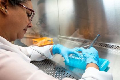 Técnica em laboratório utilizando pipeta em tubos de ensaio.