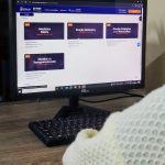 Tela de computador mostra cursos de trânsito online: Mecânica Básica, Direção Defensiva e Monitor de Transporte Escolar.