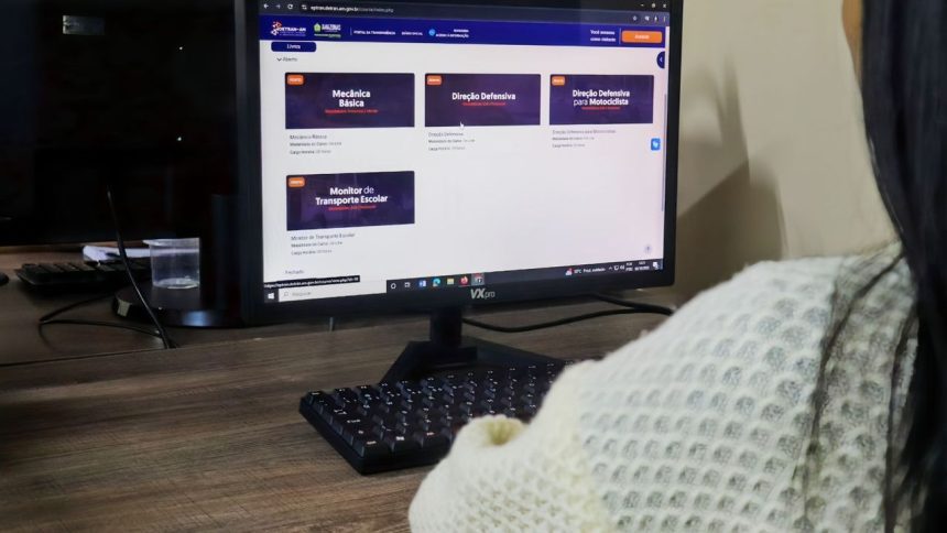 Tela de computador mostra cursos de trânsito online: Mecânica Básica, Direção Defensiva e Monitor de Transporte Escolar.