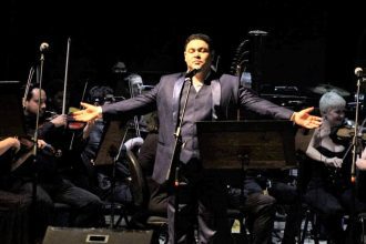 Tenor se apresenta em palco com orquestra, Encontro de Tenores no Teatro Amazonas.