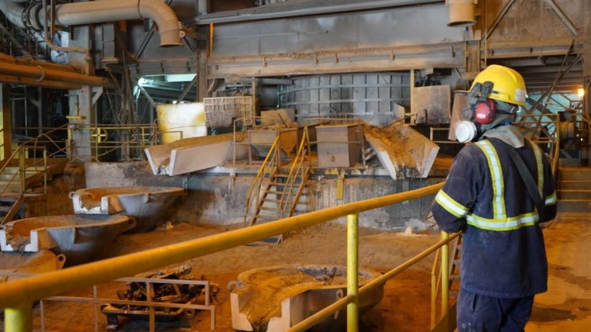 Trabalhador em fábrica de mineração com equipamento de proteção individual (EPI).