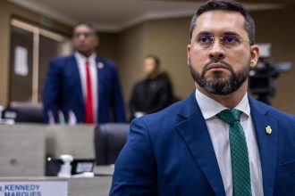 Vereador Paulo Tyrone em sessão, com outros parlamentares ao fundo.