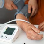 Verificação da pressão arterial com monitor digital em clínica médica.