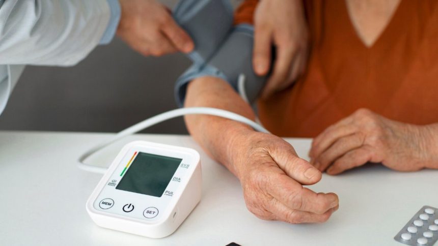 Verificação da pressão arterial com monitor digital em clínica médica.