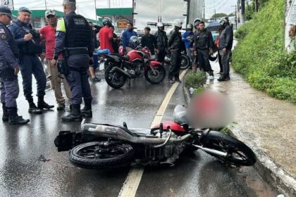 Acidente de trânsito em Manaus: motocicleta caída e policiais no local.