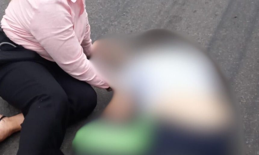 Acidente no Distrito Industrial: pessoa caída com roupa rosa e preta, com outra pessoa desfocada.