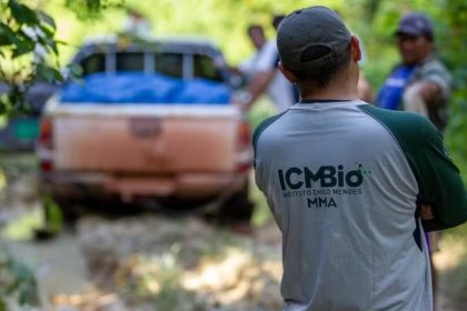 Agente ambiental do ICMBio com carro em área de mata.