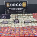 Apreensão de cocaína com embalagens empilhadas em operação policial.