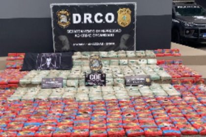 Apreensão de cocaína com embalagens empilhadas em operação policial.