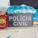 Apreensão de drogas pela Polícia Civil em Tefé, com pacotes de entorpecentes e distintivo.