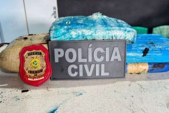 Apreensão de drogas pela Polícia Civil em Tefé, com pacotes de entorpecentes e distintivo.