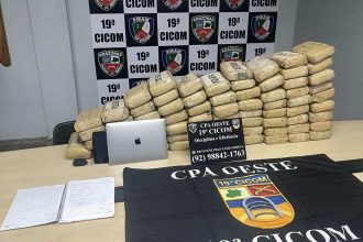 Apreensão de drogas pela polícia, com blocos embalados e materiais de investigação.