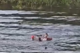 Baleeira naufragada no Igarapé Acuruí, com pessoas na água