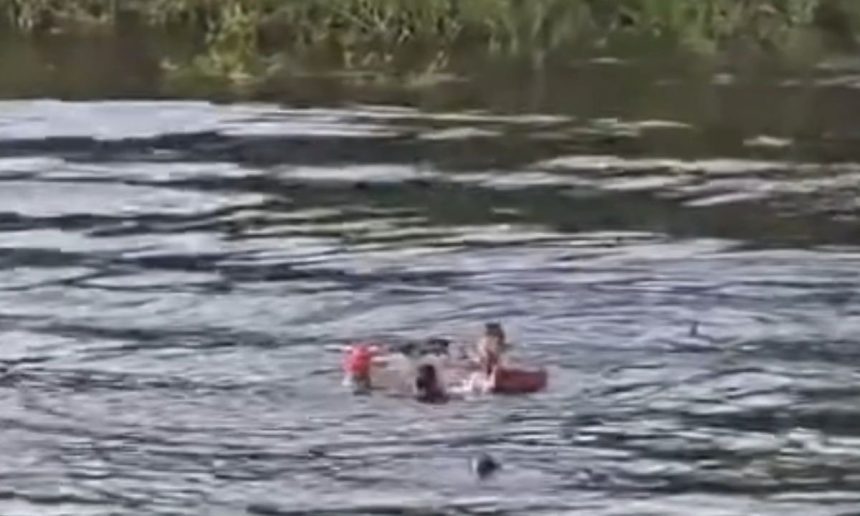 Baleeira naufragada no Igarapé Acuruí, com pessoas na água