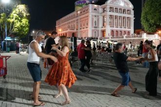 Casais dançando em frente ao Teatro Amazonas à noite
