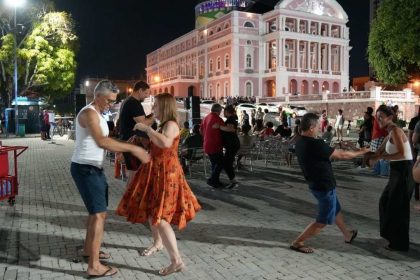 Casais dançando em frente ao Teatro Amazonas à noite