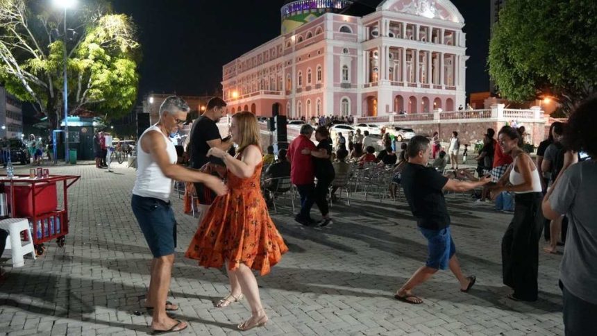 Casais dançando em frente ao Teatro Amazonas à noite