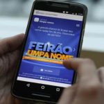 Celular mostrando a tela do Feirão Limpa Nome da Serasa, com descontos de até 90%.