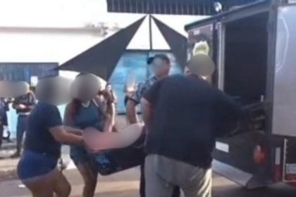 Corpos sendo retirados de festa após tiroteio no bairro Coroado