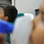 Criança recebe tratamento respiratório com máscara de inalação, em ambiente hospitalar.