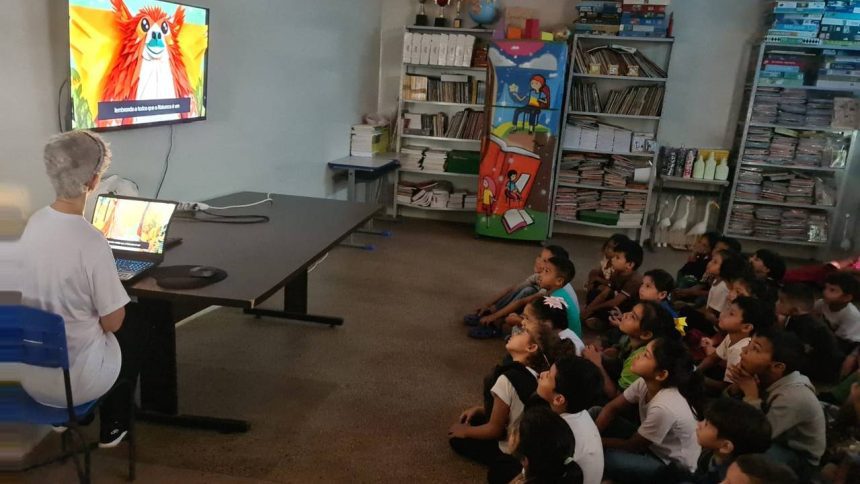 Crianças assistem a filme "Cine Mitos da Amazônia" em sala de aula.