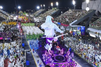 Desfile de escola de samba em Manaus com alegoria e público nas arquibancadas.
