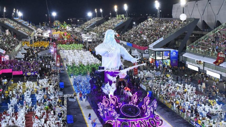 Desfile de escola de samba em Manaus com alegoria e público nas arquibancadas.