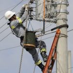 Eletricista trabalhando em poste de energia em Manaus