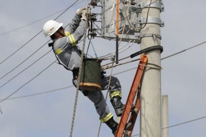Eletricista trabalhando em poste de energia em Manaus