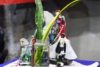 Estátuas de santos e folhagem em celebração à consciência negra no Quilombo de Manaus.