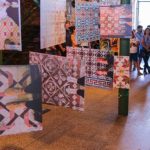 Exposição de azulejos com padrões afro-brasileiros em evento sobre patrimônio cultural.